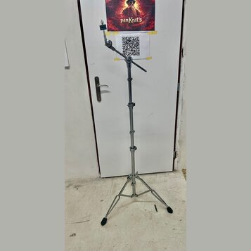 Stříbrný kovový mikrofonní stojan s trojnožkou a teleskopickým stoupacím mechanismem. Horní část obsahuje kloubový ramene s držákem na mikrofon. Na s…