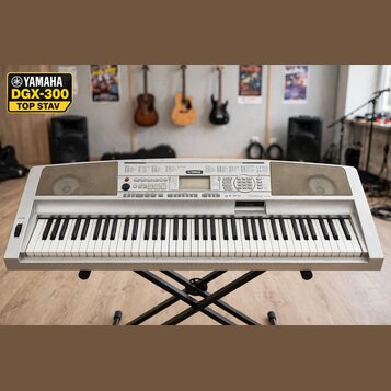 Stříbrošedý digitální klavír značky YAMAHA umístěný na černém X-stojanu. Na horním panelu je uprostřed logo YAMAHA a vpravo nápis graded Zram. Nástro…