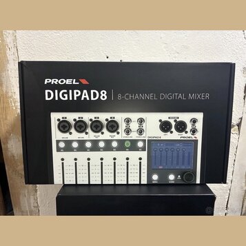 Fotografie znázorňuje krabici s digitálním mixážním pultem. Na krabici je nápis PROEL DIGIPAD8 | 8-CHANNEL DIGITAL MIXER. Zobrazený přístroj je bílý…