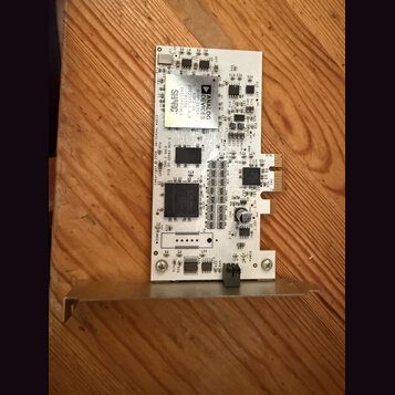 Fotografie zobrazuje elektronickou základní desku bílé barvy s osazenými součástkami. Na jedné z částí je vidět logo a nápis ANALOG DEVICES, dále tex…