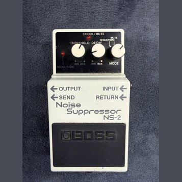 Bílý efekt pedál s černým ovládacím panelem a černým gumovým spínacím tlačítkem. Na spodní části je nápis Noise Suppressor NS-2 a logo BOSS. Horní pa…