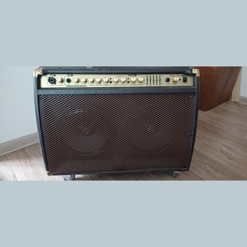 Černý kytarový kombozesilovač s kovovou mřížkou reproduktoru. Na horním ovládacím panelu jsou nápisy CH1, CH2, CHORUS, REVERB a vpravo logo AEA 60 As…