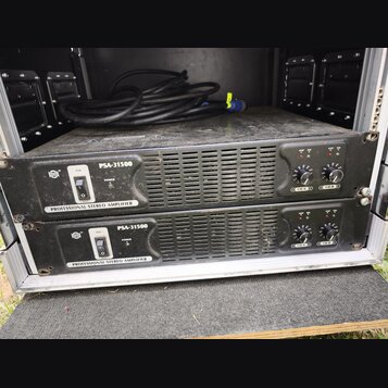 Dva černé rackové zesilovače s nápisem PSA-31500 a PROFESSIONAL STEREO AMPLIFIER. Každý jednotka má napájecí vypínač, dva ovratové knoflíky s označen…
