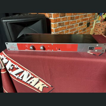 Černý rackový procesor s červeným předním panelem. Na levé straně je bílý nápis „X2“ a pod ním menší text „SOUND PROCESSOR“. Panel obsahuje dva ovrat…
