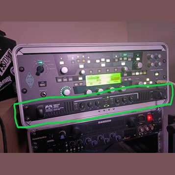 Fotografie zachycuje rackové vybavení v přenosném kufru. V zeleně vyznačené části je umístěn černý přístroj s nápisem „Palmer MH 402 ISOLATED GUITAR…