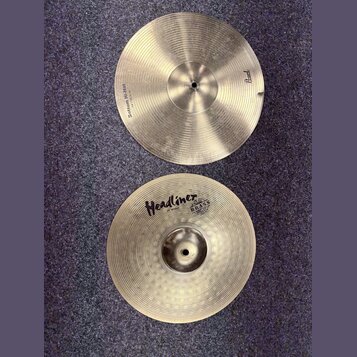 Dvě mosazné činely typu hi-hat s koncentrickým rýhováním. Horní činel má nápisy „Sottom Hi-Hat“ a „14"/35,5cm“ a logo „Pearl“. Dolní činel nese nápis…