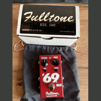Červený efekt pedál s nápisy VOLUME, FUZZ a CONTOUR. Na přední straně je velký bílý nápis '69 a menší označení MkII, v dolní části logo Fulltone® a t…