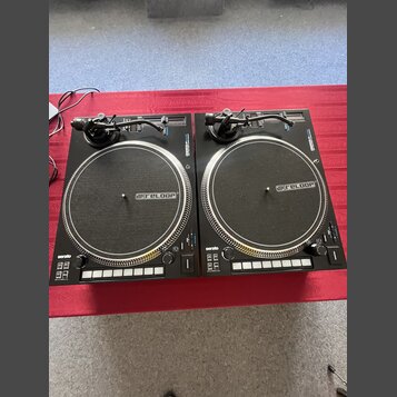 Dvě černé turntable gramofony s logem @reloop na talířích. V levém dolním rohu obou přístrojů je nápis serato. Povrchy jsou v dobrém stavu, bez vidit…