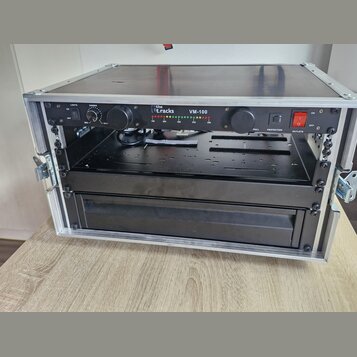 Černý rackový kondenzační rozvodč s nápisy the t.racks a VM-100, umístěný v hliníkovém transportním kufru. Přední panel obsahuje regulační knoflíky,…