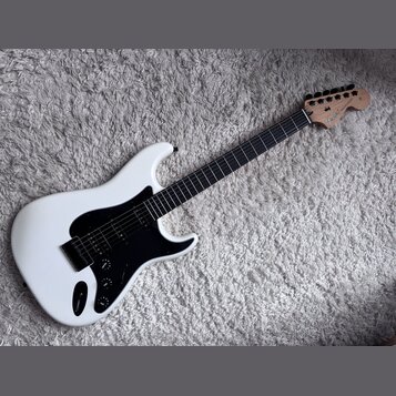 Bílá elektrická kytara s černým pickguardem a hmatníkem z tmavého dřeva. Na hlavě je viditelné logo „Fender“ a nápis „STRATOCASTER“. Nástroj má jeden…