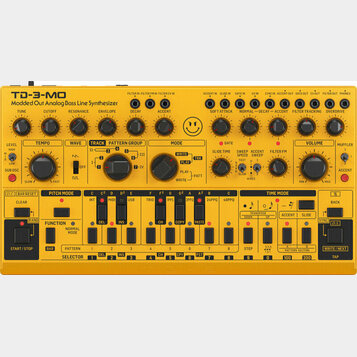 Žlutý analogový basový syntetizátor s nápisem TD-3-MO Modded Out Analog Bass Line Synthesizer. Přístroj obsahuje zahlreiche černé ovládací knofíky, p…