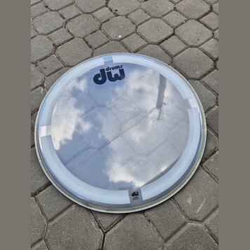 Průhledná kruhová bubenová blana s bílým okrajem. V horní části je černé logo „drums dw“. V dolní části je menší nápis „dw“ a pod ním nečitelný text.…