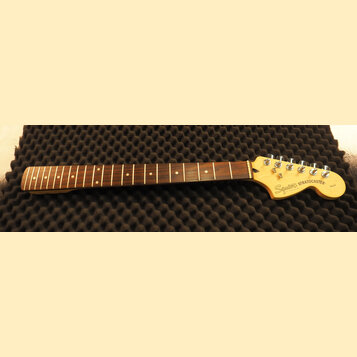 Hmatník elektrické kytary z tmavého dřeva s bílými polohovými značkami. Světle žlutá hlava kytary nese nápisy Squier a STRATOCASTER, v dolní části je…