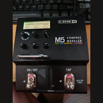 Černý efekt pedál s nápisy LINE 6 a M5 STOMPBOX MODELER. Pod názvem modelu jsou uvedeny kategorie DELAY | MOD | DISTORTION | FILTER | VERB. Displej z…