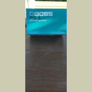 Modrá krabice s bílými nápisy. Na přední straně je logo BOSS a text PS-5 SUPER Shifter. V pravém dolním rohu je malý bílý štítek s nápisem USE BOSS P…