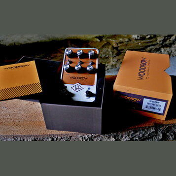 Kompaktní kytarový zesilovač v béžovém provedení s kovovým rámem. Na přední straně je nápis WOODROW 55 Instrument Amplifier a logo UA v kosočtverci.…