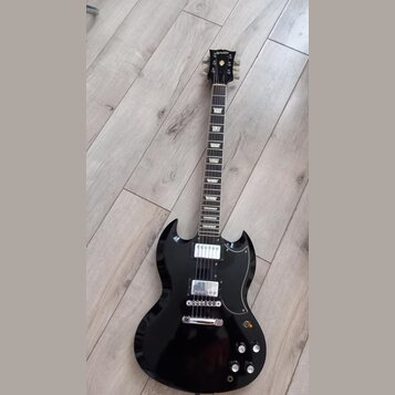 Černá elektrická kytara s dvojsekyrou v tvaru SG. Na hlavě hmatníku je bílý nápis Urville a zlatý znak. Nástroj má dva humbuckery, stříbrný most s ko…
