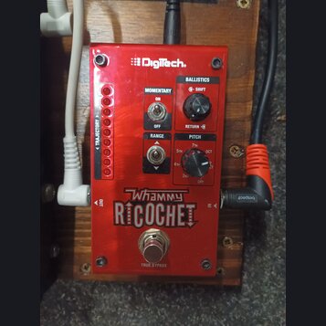 Červený efekt pedál značky DigiTech s nápisem Whammy RICOCHET. Na horní straně jsou přepínače MOMENTARY (ON/OFF) a RANGE, otočný potenciometr BALLIST…