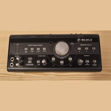 Černý monitor kontroler s nápisem BIG KNOB STUDIO COMMAND SYSTEM. Zařízení obsahuje centrální ovladač VOLUME, sekce INPUT SOURCE SELECT s tlačítky DA…