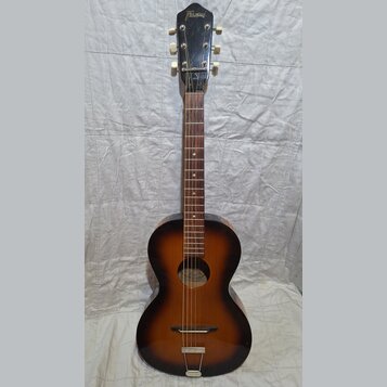 Akustická kytara s tmavě hnědým přechodem do žluté barvy (sunburst). Na hlavě je bílý nápis Framus. Nástroj vykazuje známky opotřebení, zejména v pod…