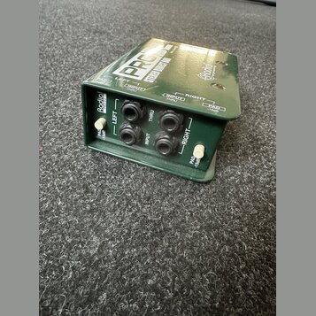 Zelený kovový DI box s nápisy PRO48 STEREO DIRECT BOX a logem Radial Instruments. Na předním panelu jsou čtyři konektory XLR, dva přepínače PAD -15dB…