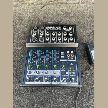 Černý kompaktní mixážní pult s nápisem Mix8 8-CHANNEL COMPACT MIXER. Horní část obsahuje vstupy Gain a AUX, spodní část je vybavena modrými a zeleným…