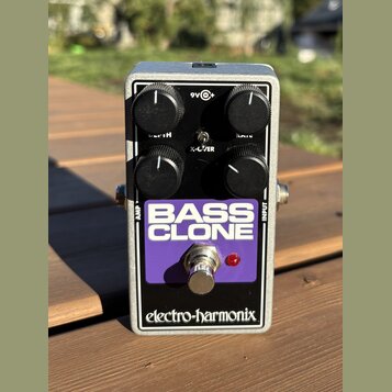 Stříbrný efekt pedál v kovovém šasi s fialovým panelem. Na panelu je bílý nápis BASS CLONE a v dolní části černý pruh s bílým logem electro-harmonix.…
