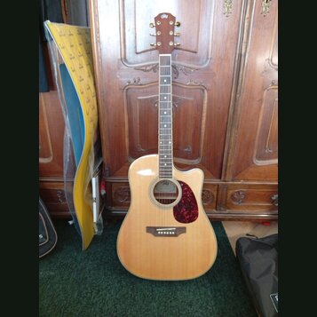 Akustická kytara s cutawayem v přirozené dřevěné barvě a červeným puntovaným pickguardem. Na hlavě hmatníku je viditelné logo Epiphone. Hmatník obsah…
