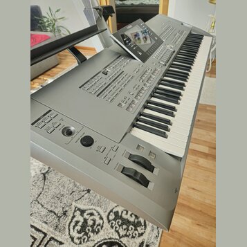 Stříbrný digitální klavír s klávesnicí a ovládacím panelem. V horní části je umístěn displej s nápisem YAMAHA. Na levé straně jsou ovládací prvky, vč…