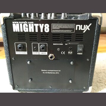 Zadní strana černého komba s nápisy www.nuxefx.com, MIGHTY8 a logem nux. Jsou zde vidět vstupy a výstupy s popisky MIXER PHONES, CD/MP3, LINE IN, DC…