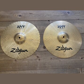 Dvě mosazné činely značky Zildjian s viditelným rakováním. Levý činel nese nápisy ZHT a Mastersound Hihat Bottom 13"/33 cm. Pravý činel má nápisy ZHT…