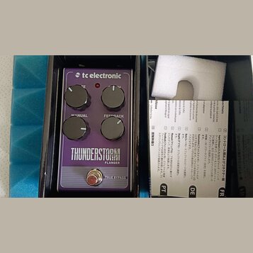 Fialový efekt pedál značky tc electronic s nápisem THUNDERSTORM FLANGER. Na horní straně jsou čtyři černé ovládací knoflíky s popisky MANUAL, FEEDBAC…