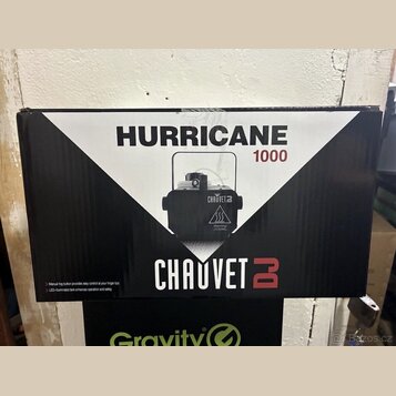 Fotografie znázorňuje kartónovou krabici s černobílým potiskem. Na krabici je uveden název HURRICANE 1000 a logo CHAUVET DJ. Uprostřed je vyobrazen č…