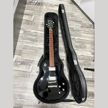 Černá elektrická kytara v otevřeném černém tvrdém pouzdře. Na hlavě hmatníku je bílý nápis Epiphone. Nástroj má dva humbuckery, čtyři ovládací knoflí…
