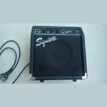 Černý kytarový kombo zesilovač s texturovaným povrchem a kovovými rohy. Na horním ovládacím panelu jsou nápisy INPUT, VOLUME, TREBLE, BASS, HEADPHONE…