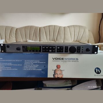 Šedý rackový procesor s nápisem VOICEWORKS a logem TC-HELICON. Zařízení má digitální displej, několik tlačítek, dva otočné ovladače a konektory na za…
