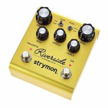 Zlatý kytarový efekt s nápisy Riverside multistage drive a strymon. Pedál má pět černých ovládacích knoflíků s bílými vršekmi a popisky DRIVE, BASS,…