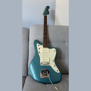 Modrá elektrická kytara s bílým pickguardem a hnědým hmatníkem. Na hlavě je viditelné logo Fender. Kytara má jeden snímač typu humbucker u kobylky a…