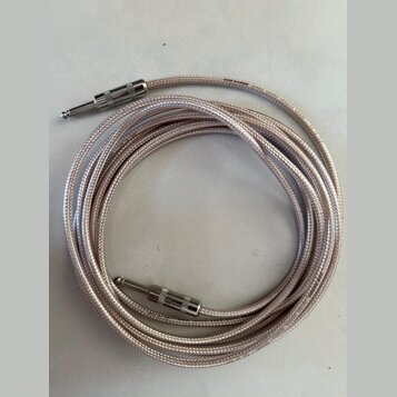 Stříbrný pletený instrumentální kabel s dvěma 6,3mm jack konektory. Konektory mají kovové stínění s drážkovaným povrchem. Na kabelu jsou viditelné ne…