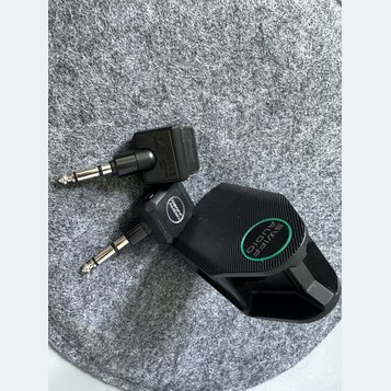 Dvě černé redukce jack konektorů. Na jedné je vidět nápis „SWIFFE AUDIO“ v zeleném kruhu a stejný nápis menším písmem na těle redukce. Druhá redukce…