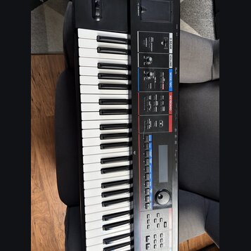 Černý digitální klávesový nástroj s bílými a černými klávesami. Na ovládacím panelu jsou viditelné nápisy D BEAM, VOLUME, MODE/MIC a KEYBOARD. Jsou z…
