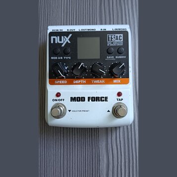 Bílý efekt pedál s nápisem MOD FORCE. Na horní části jsou čtyři černé ovládací knoflíky s popisky SPEED, DEPTH, TWEAK a MIX, displej a nápisy nux, TS…