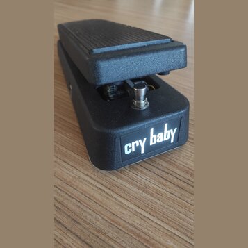 Černý kytarový wah-pedál s texturovaným povrchem. Na přední straně je bílý nápis cry baby. Nástroj vykazuje mírné známky používání v podobě drobných…