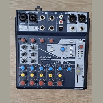 Mixážní pult s modrým povrchem a černým rámem. Na předním panelu je bílý nápis Soundcraft a pod ním model NOTEPAD-8FX. V horní části je sekce EFFECTS…