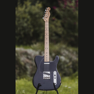 Elektrická kytara typu Telecaster v černé barvě s černým pickguardem a světlým hnedým hmatníkem. Na hlavě je viditelné logo Fender Telecaster. Tělo v…
