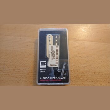 Elektrický snímač typu humbucker v původním plastovém obalu. Na bílém štítku je uveden text „Seymour Duncan ApH-ZN Slash Alnico II Pro ZN Humbucker P…