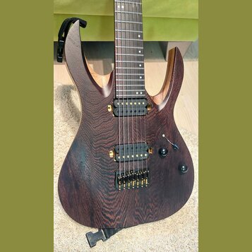Elektrická kytara s tmavě hnědým dřevěným povrchem a výraznou strukturou zrna. Nástroj má dva humbuckery s černými snímači a zlatým hardwarem, včetně…