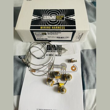 Fotografie zobrazuje zapojovací sadu pro kytaru v bílém originálním kartonu s nápisy MOJO GUITAR TONE TECH. a WIRING HARNESS. Sada obsahuje čtyři pot…