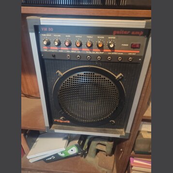 Kytarový kombo zesilovač s černým předním panelem a stříbrným rámem. V horní části je nápis VM 30 a guitar amp, v dolní části logo regent. Ovládací p…