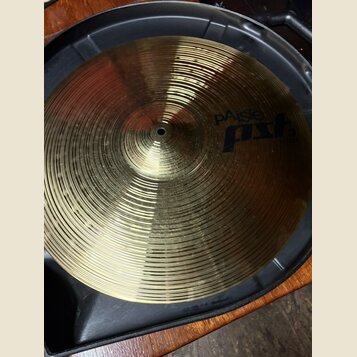 Kovový činel zlaté barvy s koncentrickými rýhami na povrchu. Na pravé straně je modrý nápis pAiste pst 3. Činel je umístěn v černém plastovém obalu.